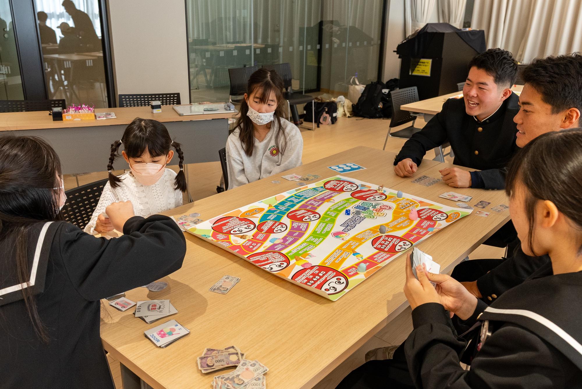 すごろくで遊ぶ高校生と子ども