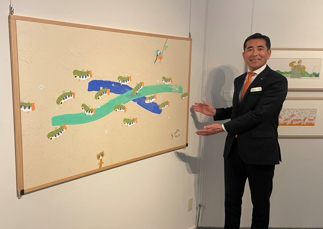 村上やすなりさんの絵を紹介する市長