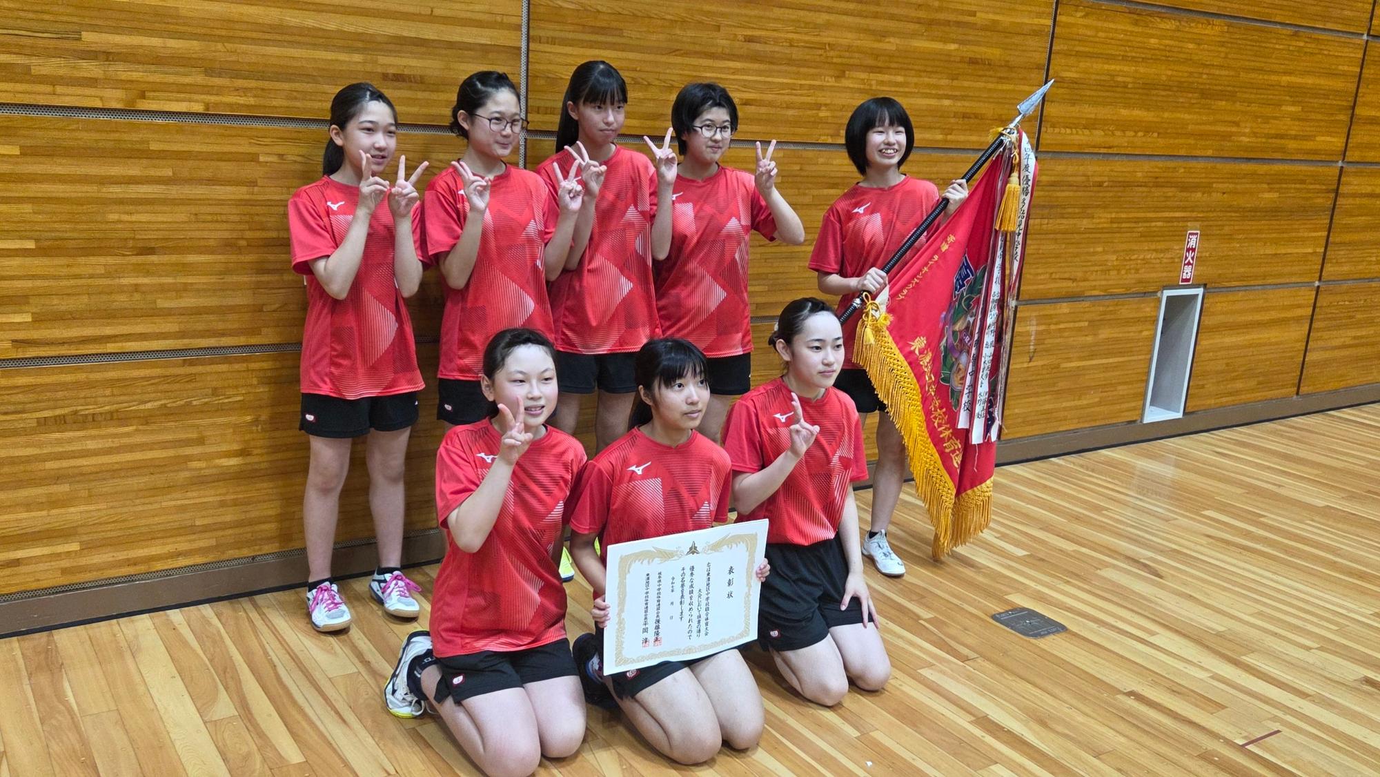 優勝旗を手に記念撮影の女子卓球部