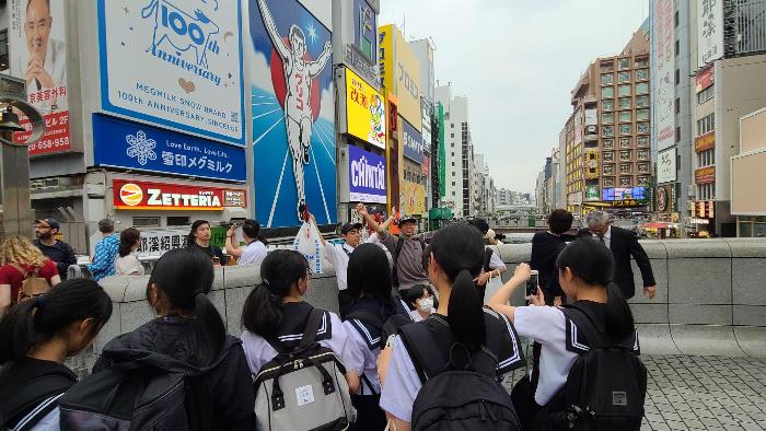 戎橋でグリコの看板を背に記念写真を撮る3年生