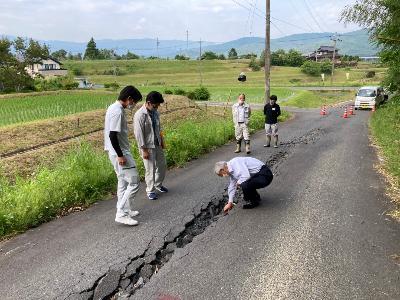 ひび割れした被災道路を市長とスタッフが視察している様子