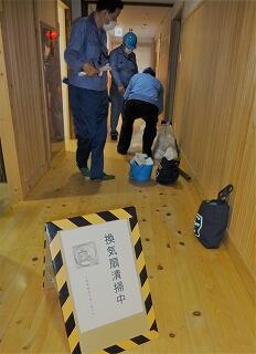 公民館の廊下で換気扇清掃の作業をしています