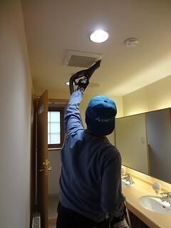 天井の換気扇を掃除機で掃除しています