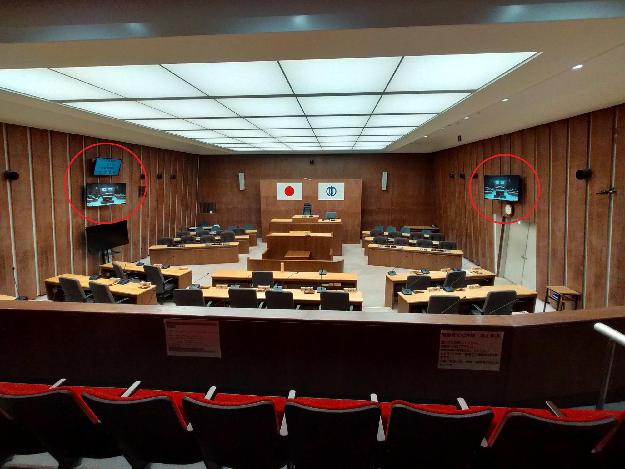 議場の両壁面に設置してあるモニターを傍聴席からみた様子
