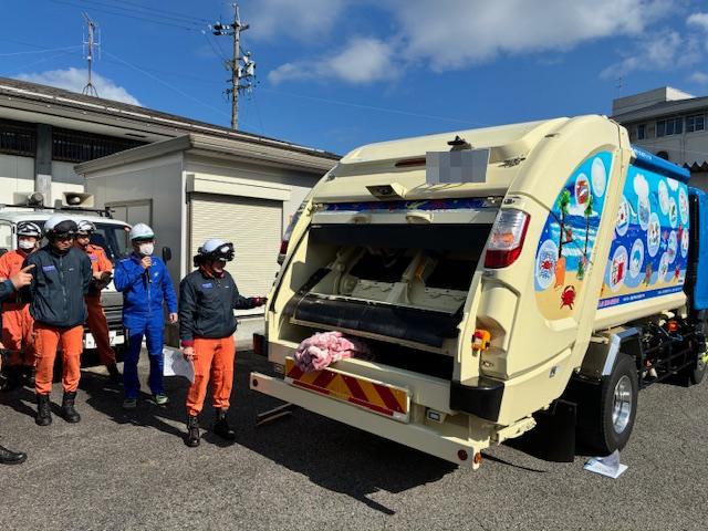 女性隊員がゴミ収集車の操作を体験している様子。