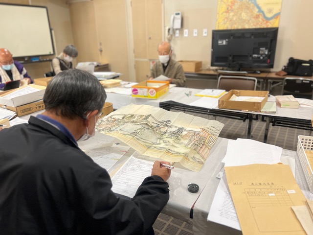 書画の資料を確認する調査員