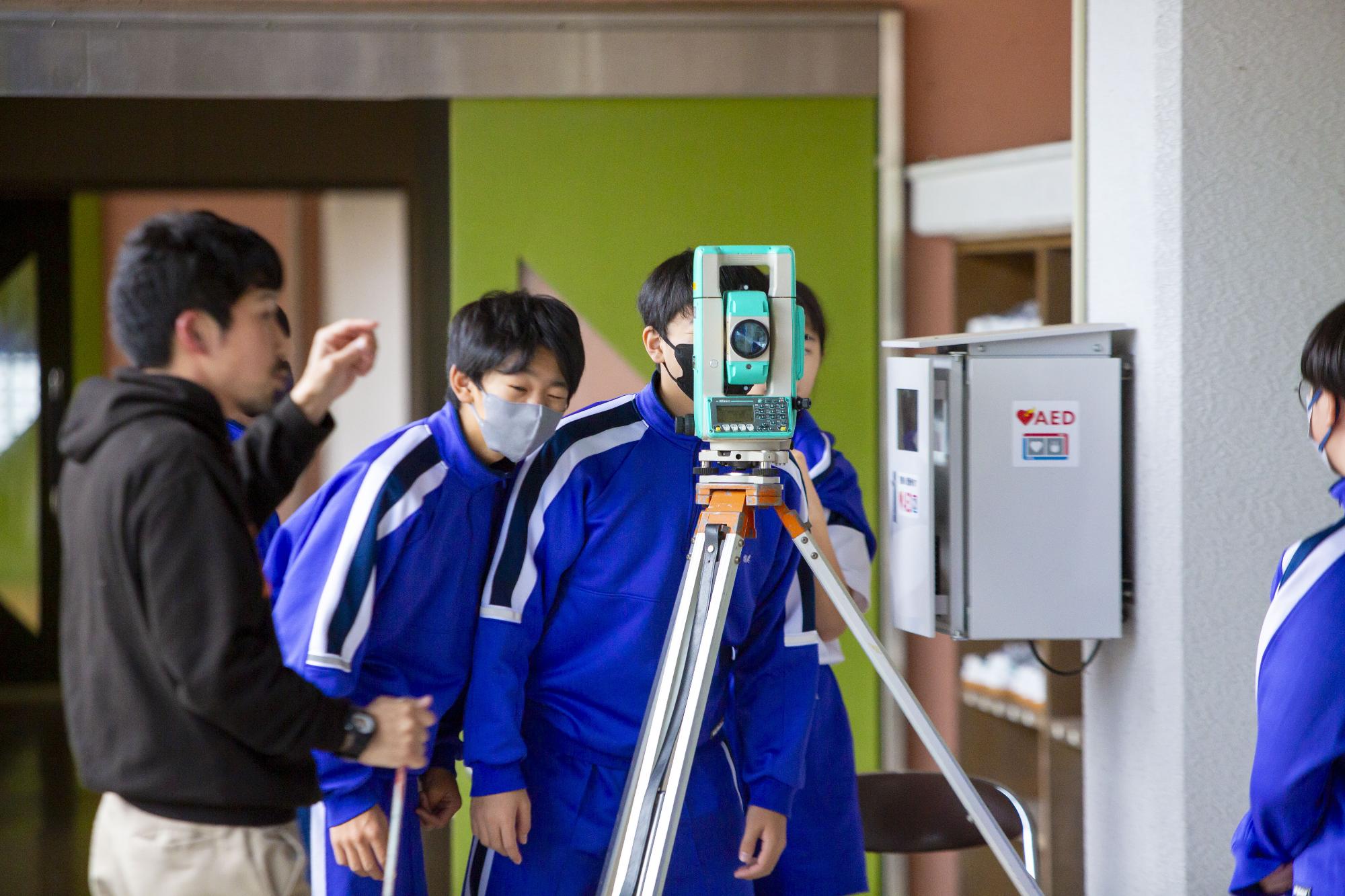 説明を受けながら実際に仕事を体験する生徒たち