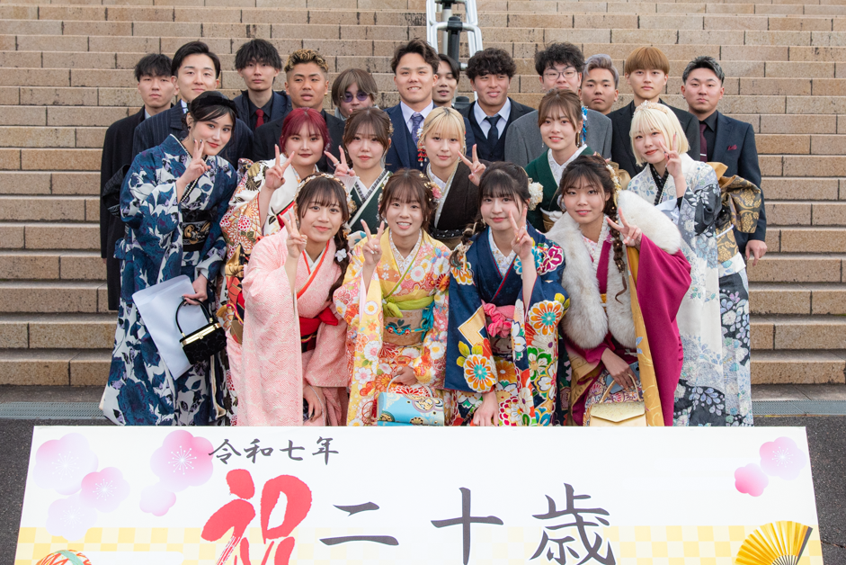 看板とともに記念撮影をする二十歳の皆さん