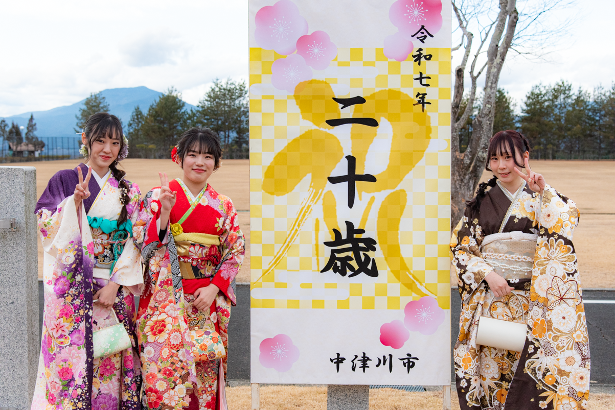 看板とともに記念撮影をする二十歳の皆さん