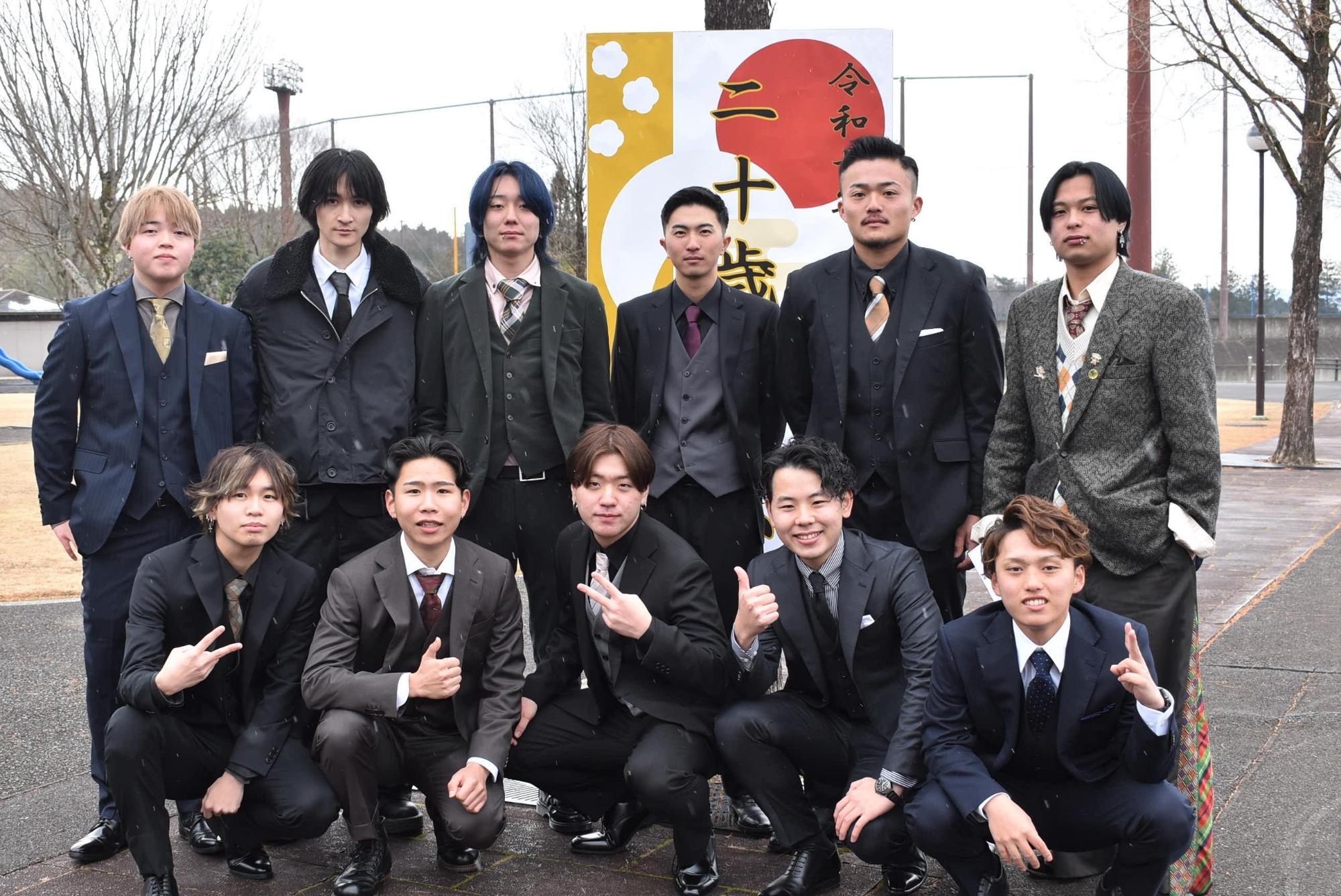看板とともに記念撮影をする二十歳の皆さん