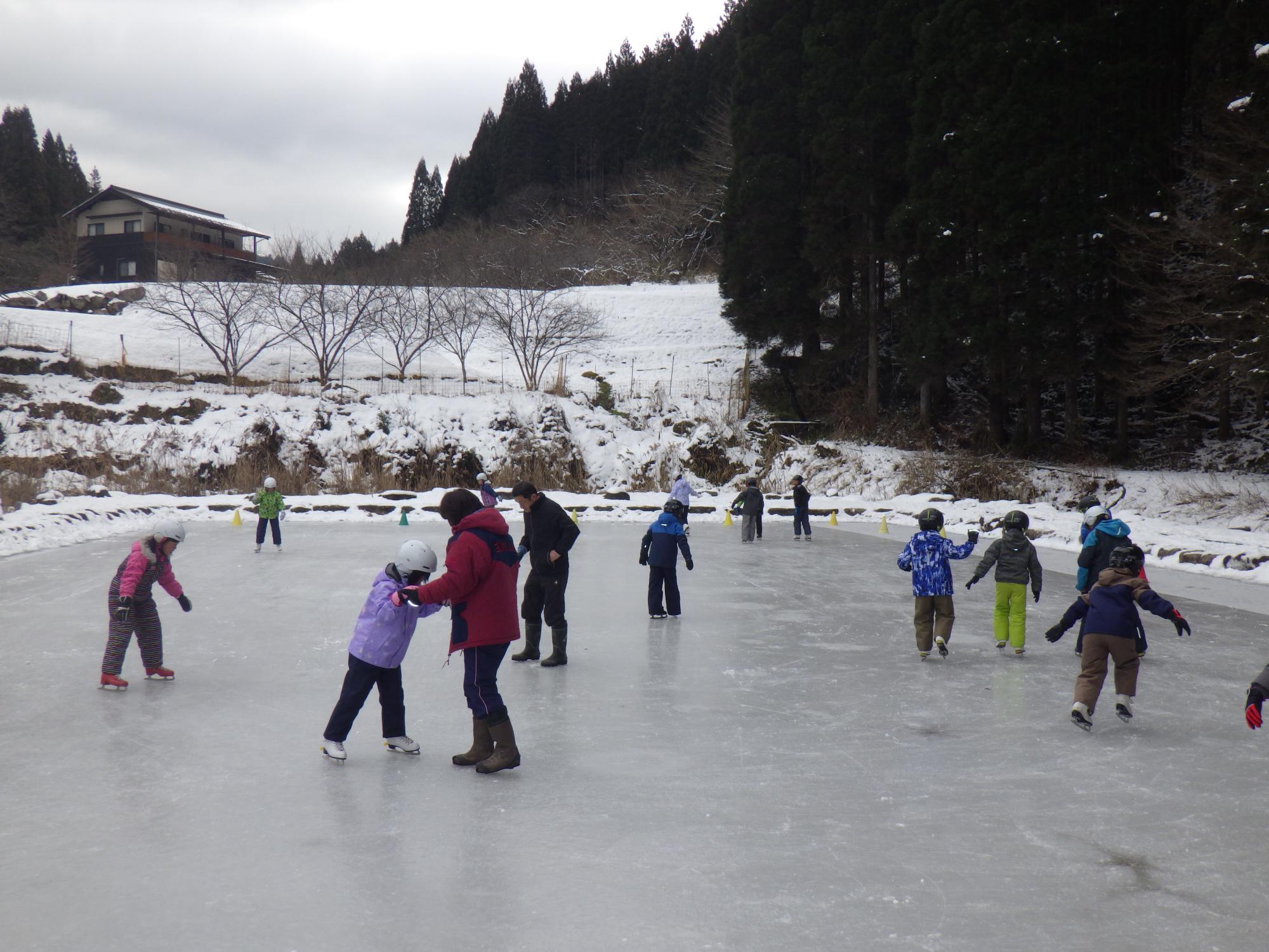天然のスケート場で楽しそうに滑る小学生たち
