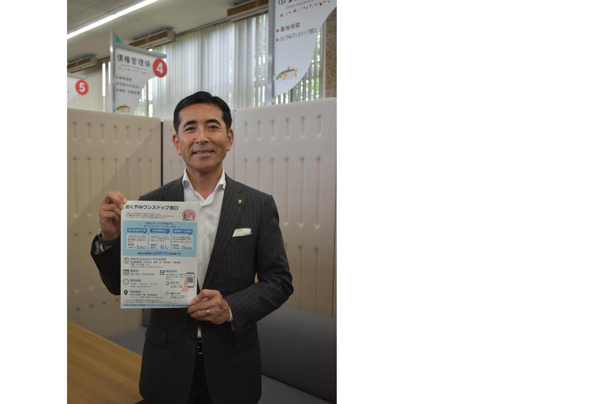 チラシを持つ市長
