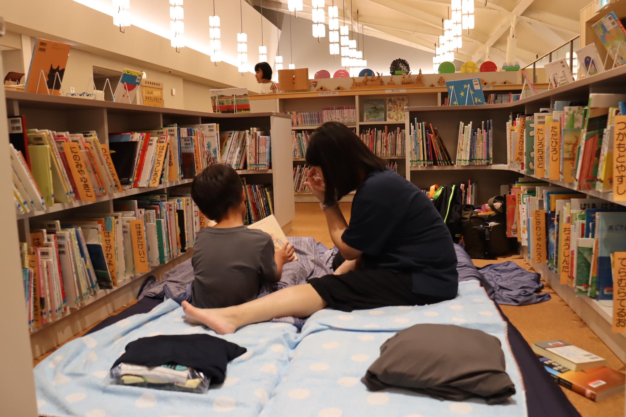 図書館に寝袋を敷いて、好きな本を読んで過ごす親子