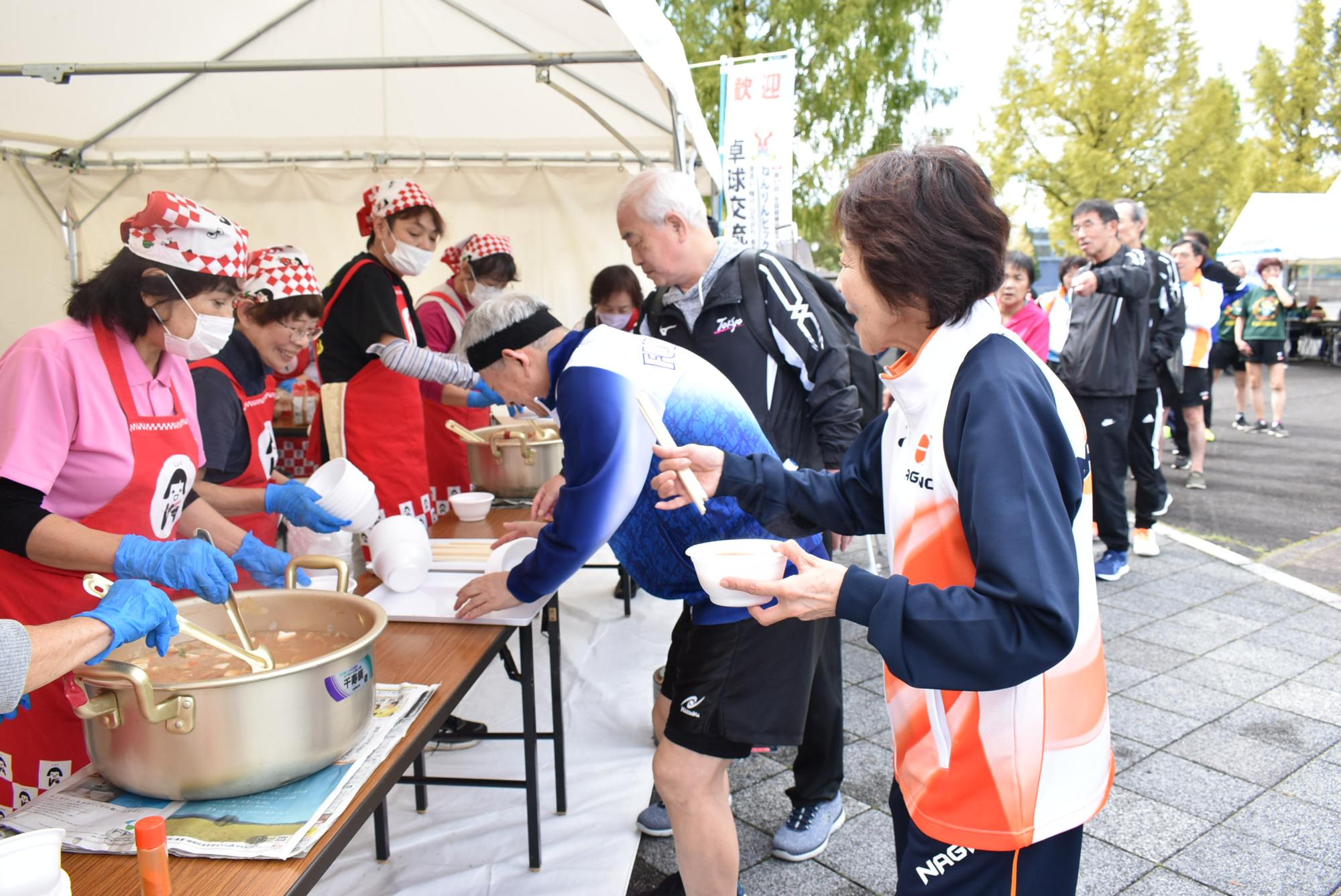 ねんりんピック岐阜2025中津川市大会卓球交流大会で豚汁のふるまいに行列ができている様子
