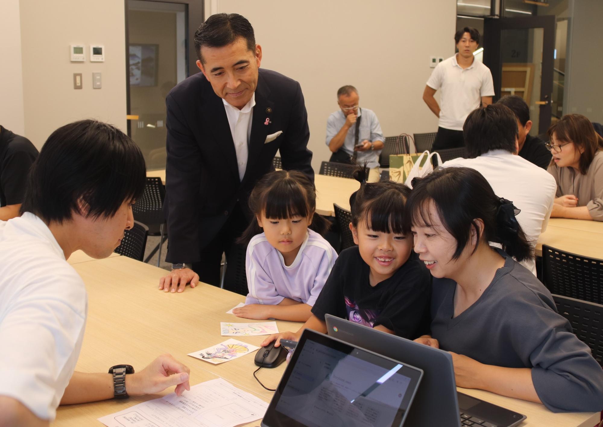 生成AIを体験する親子と見守る市長