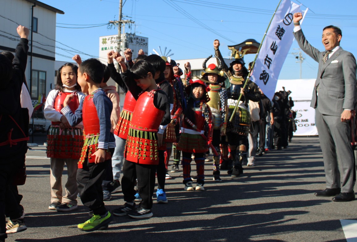 市長が武将隊の出発式でかけ声をかけている。えいえいおー！