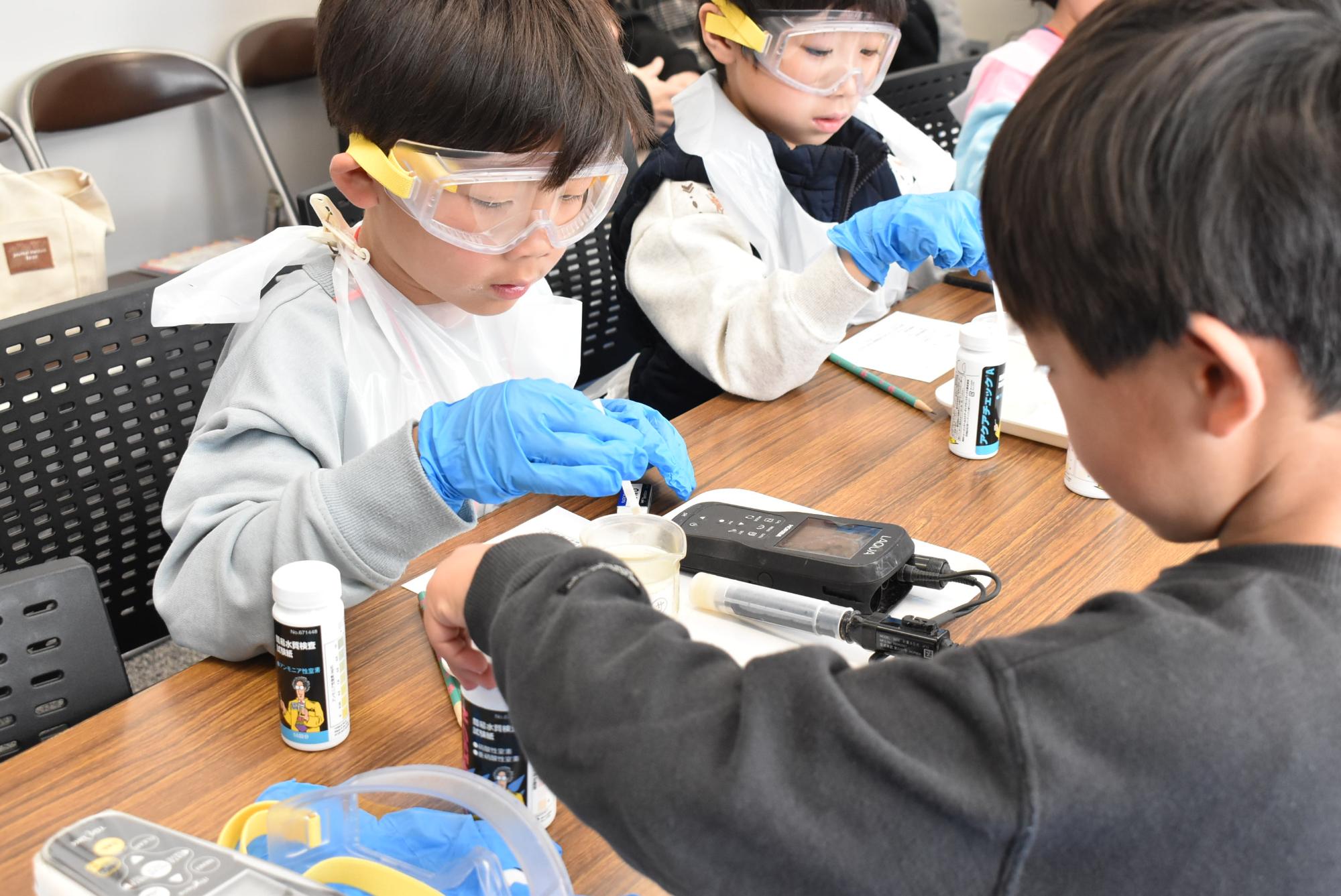 水質管理のお仕事体験をしている小学生たち