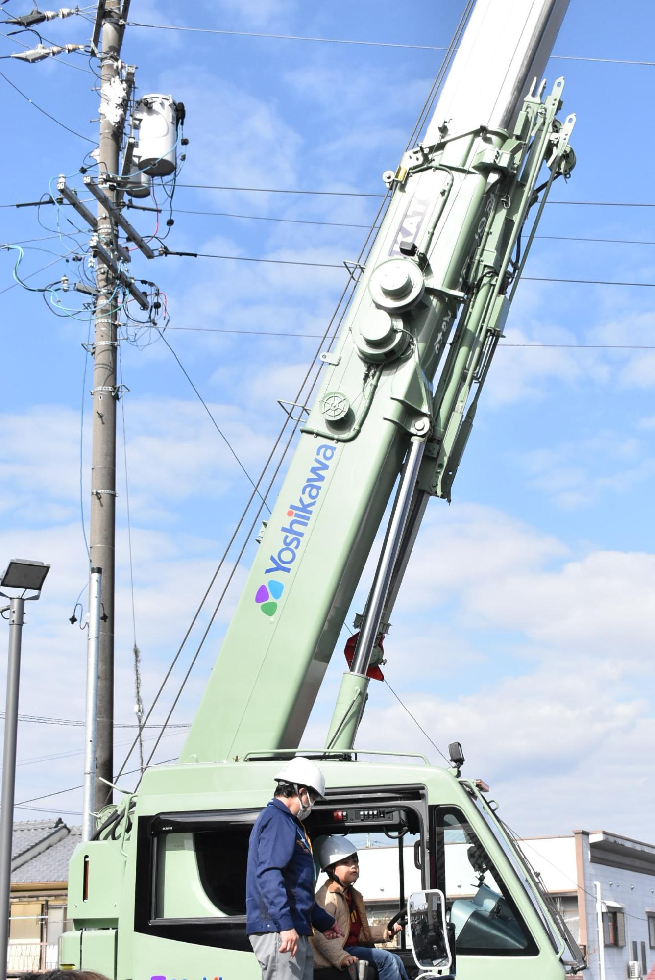 クレーン車に乗る体験をする子ども