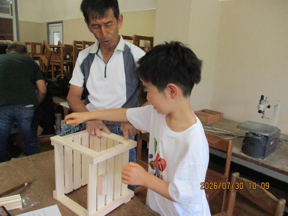 おうちの方に作品を支えてもらいながら、ヤスリがけをしているところ