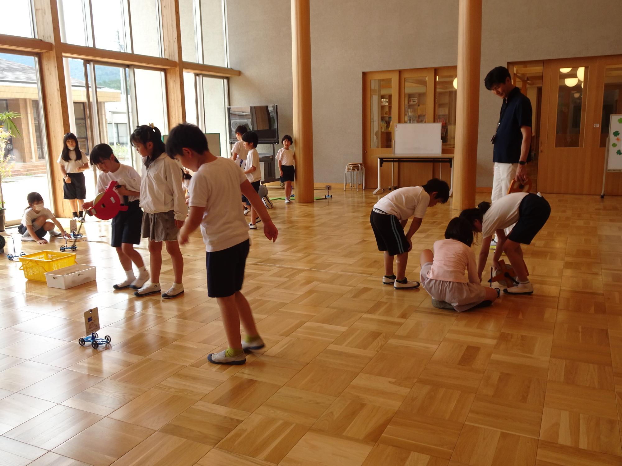 風で動く車を走らせる子ども