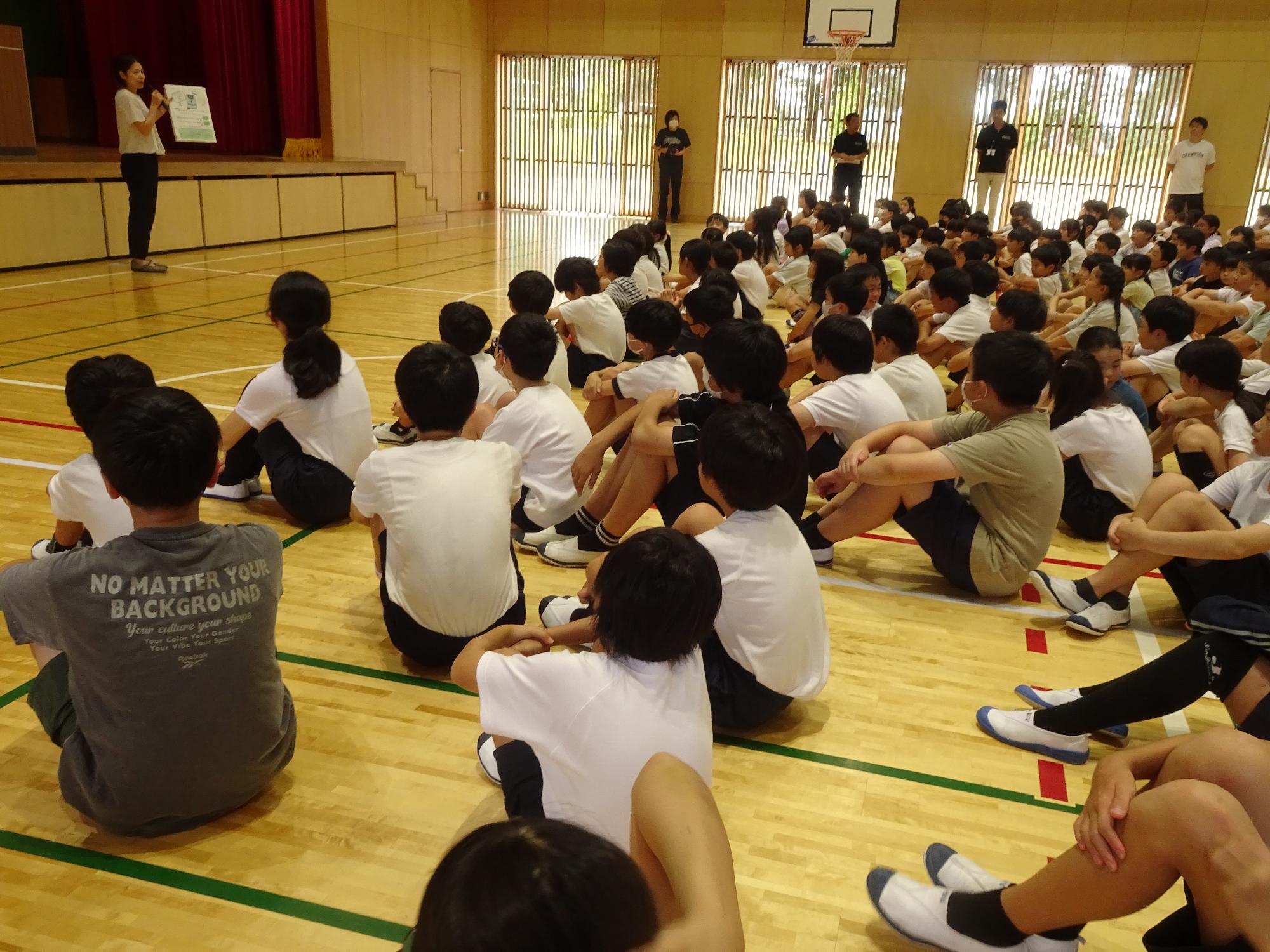 先生の話を聞く子どもたち