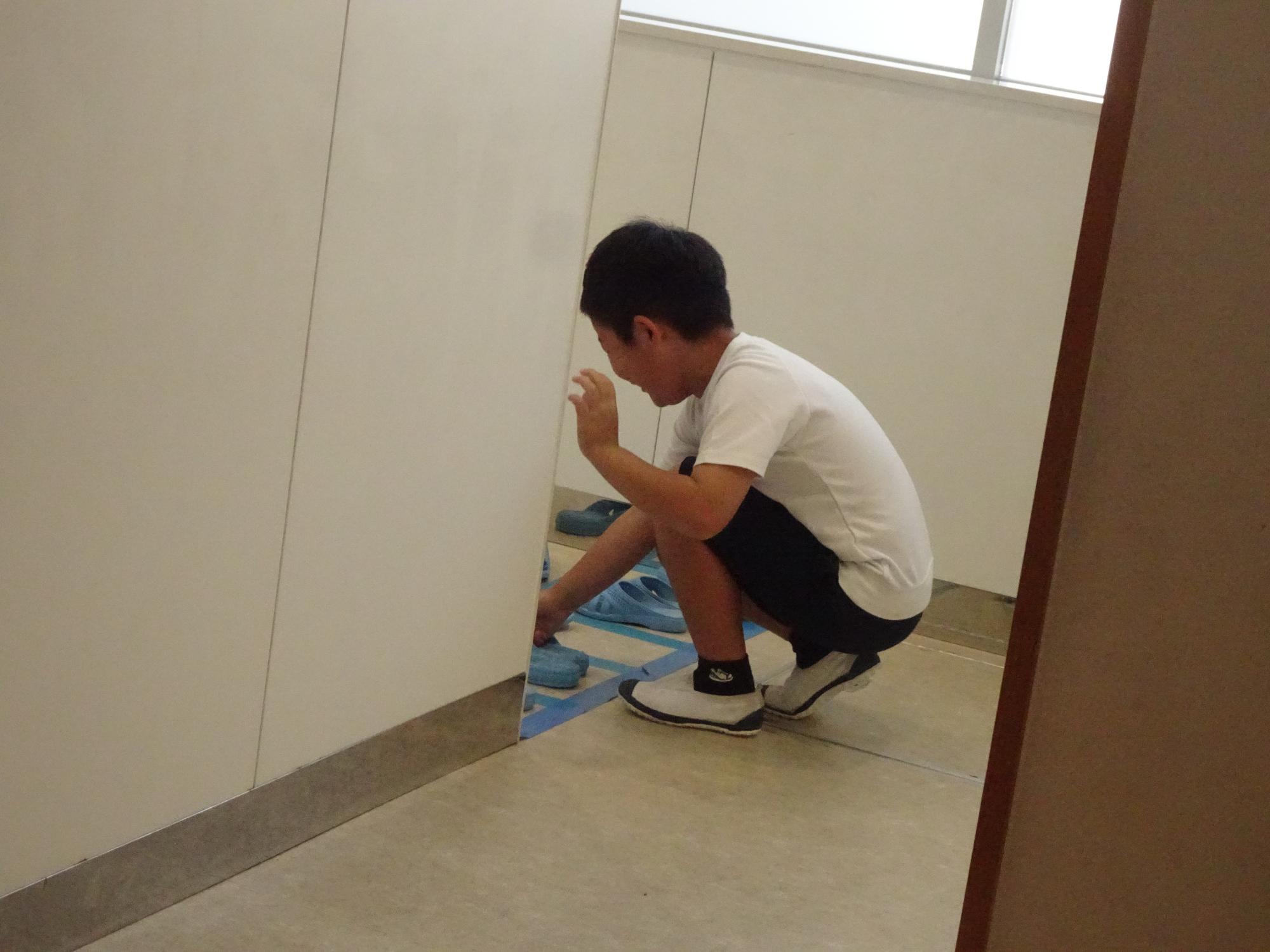 トイレのスリッパを整頓する子ども