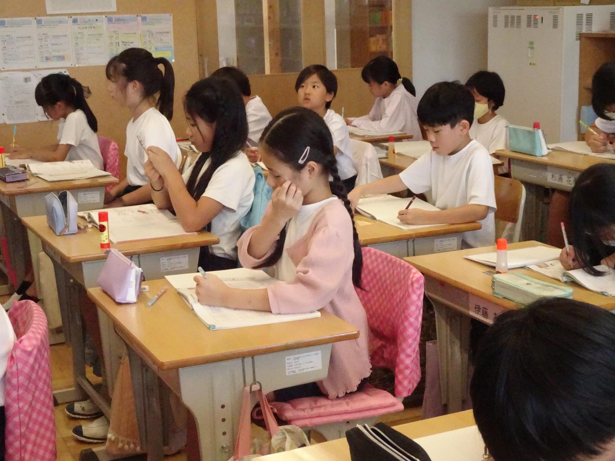 背筋を伸ばして字を書く子ども