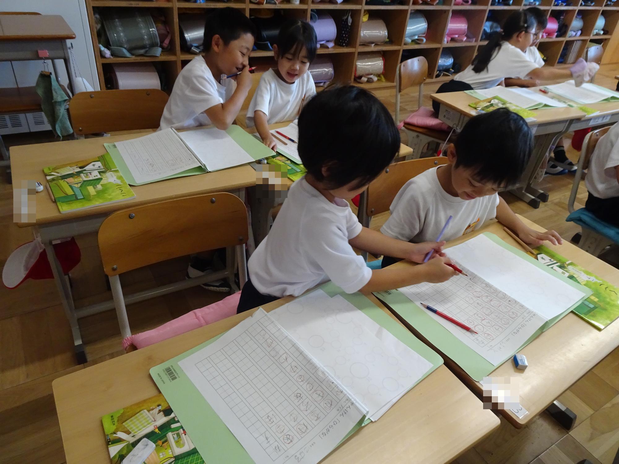 字を教え合う子ども