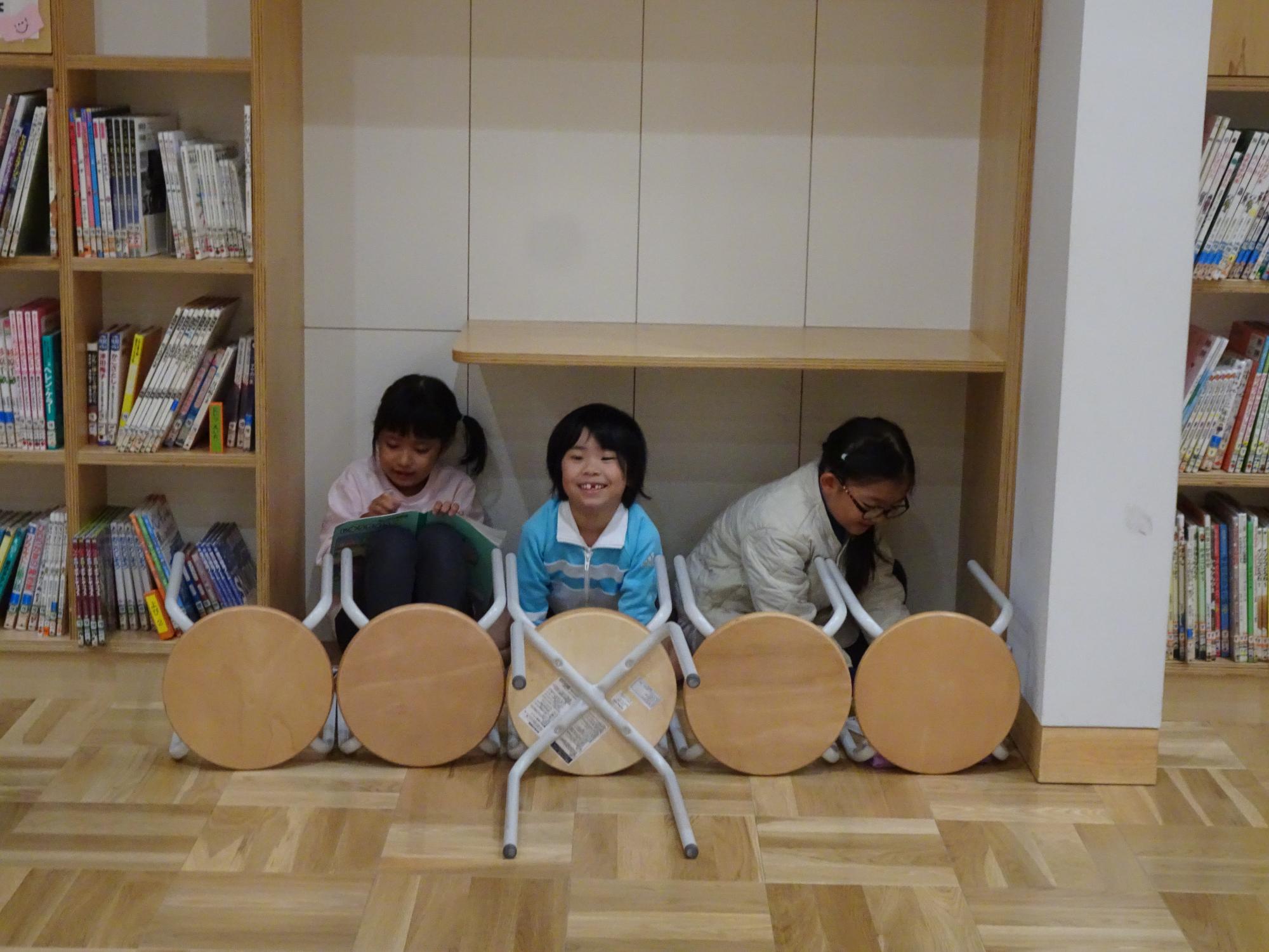 いすを並べて遊ぶ子供