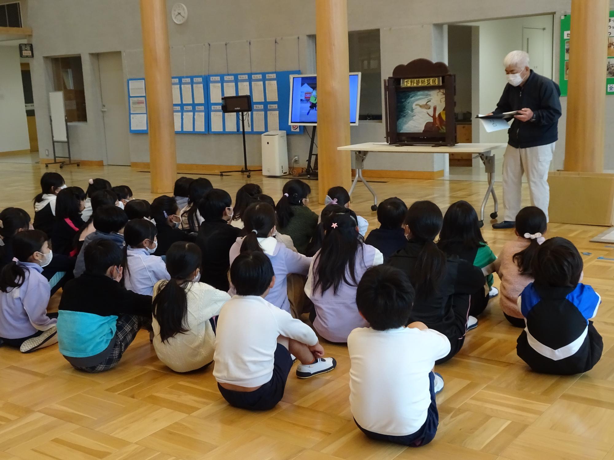 紙芝居を聞く子