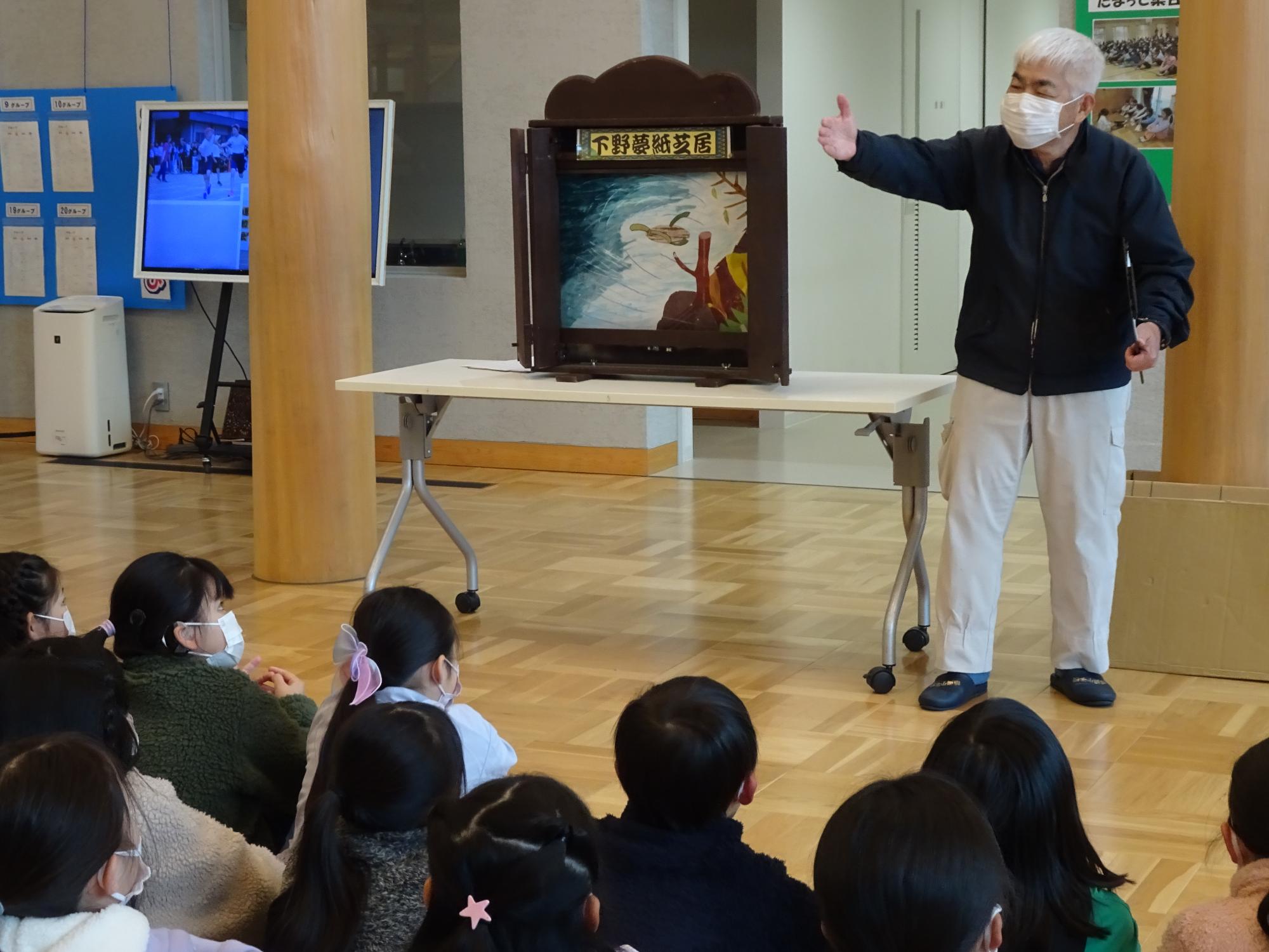 紙芝居を聞く子