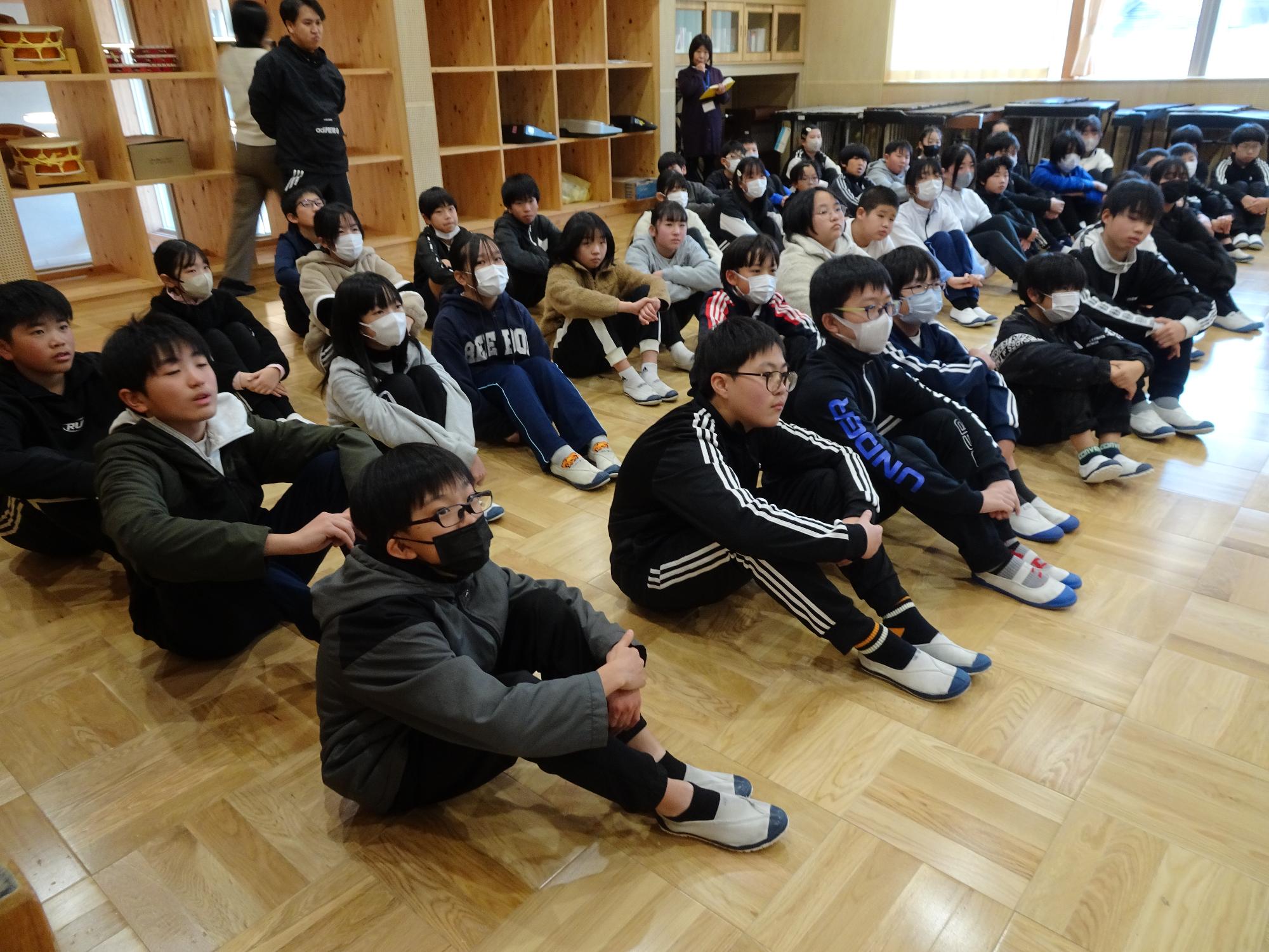 中学校の先生の話を聞く6年生