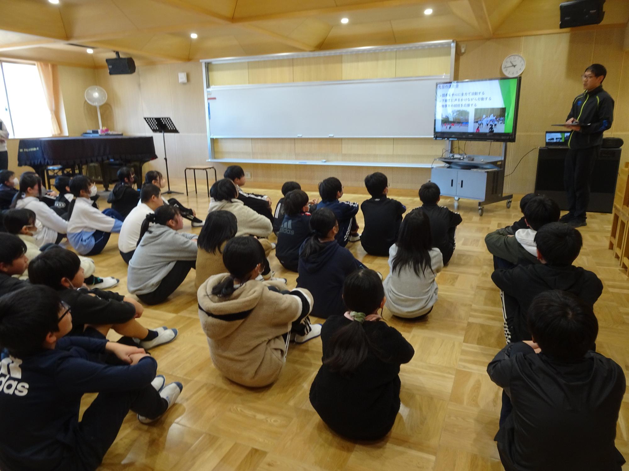 中学校の先生の話を聞く6年生