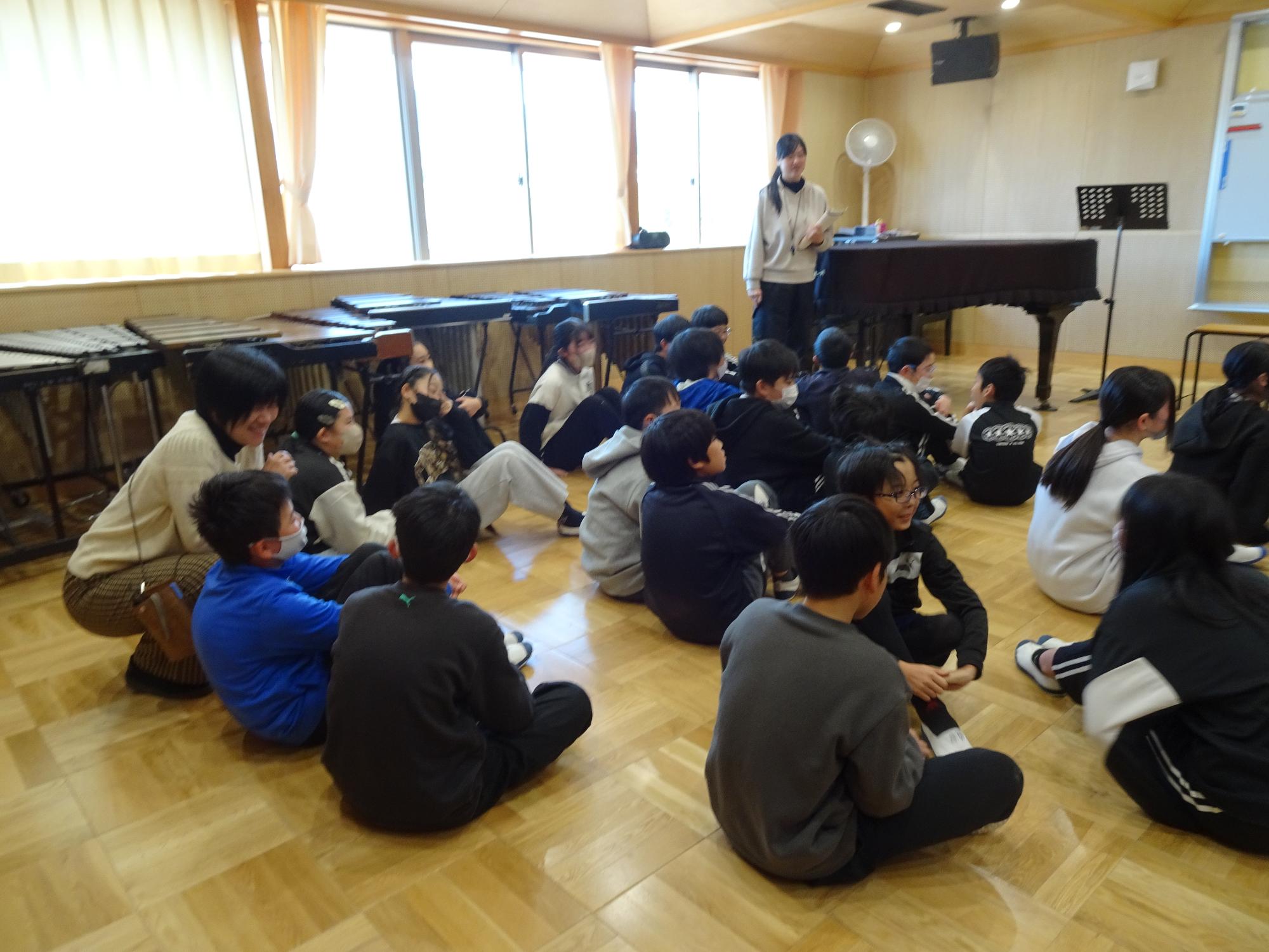 中学校の先生の話を聞く6年生