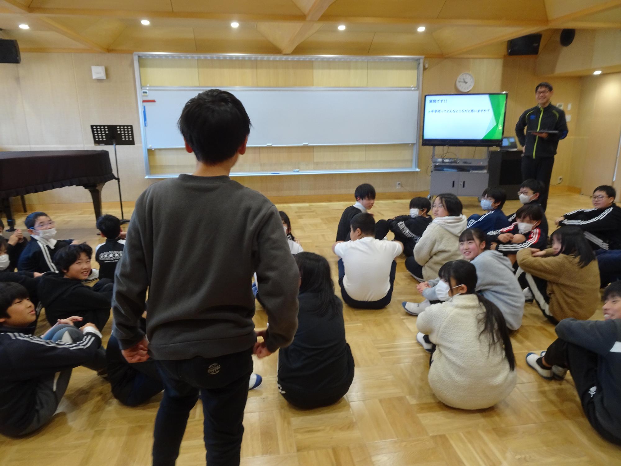 中学校の先生の話を聞く6年生