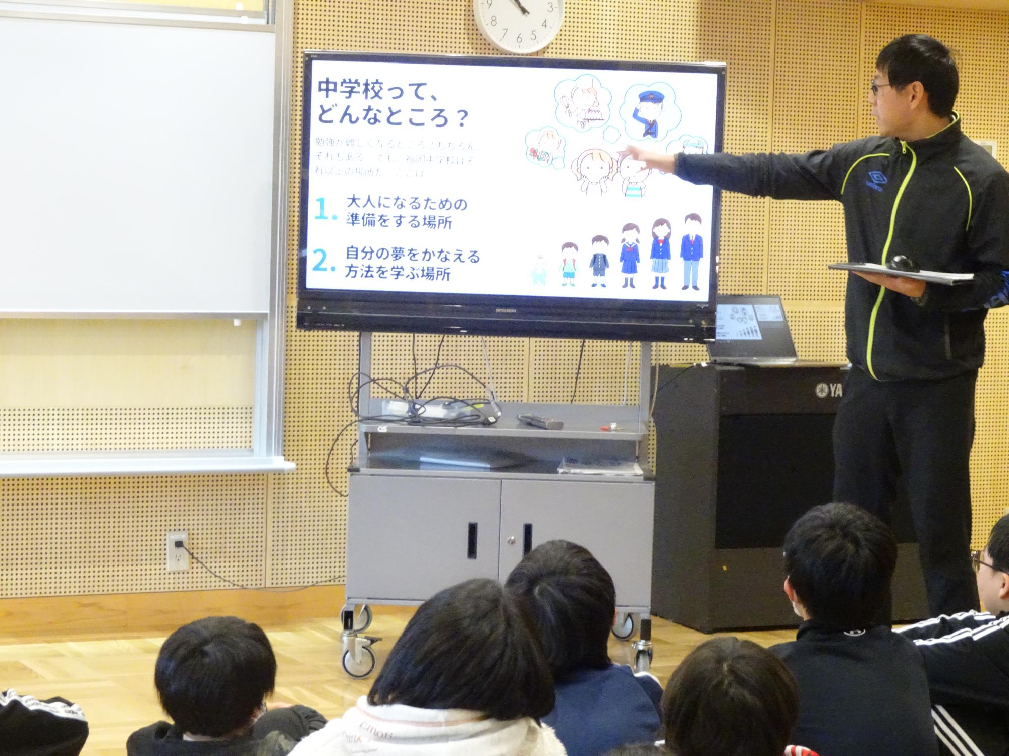 中学校の先生の話を聞く6年生