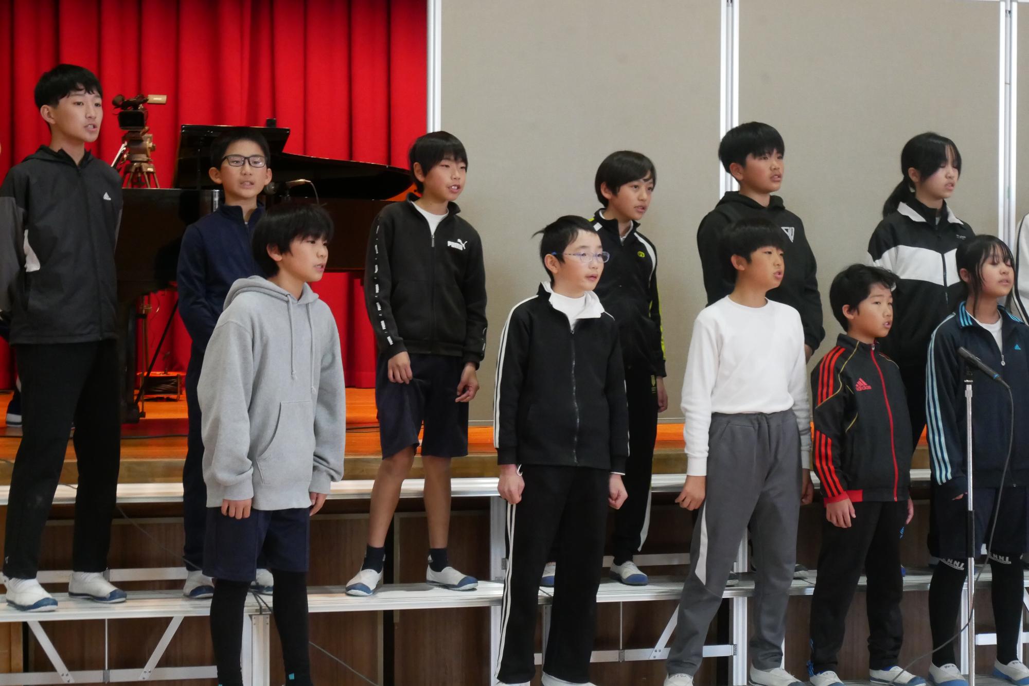 中学校で合唱する6年生