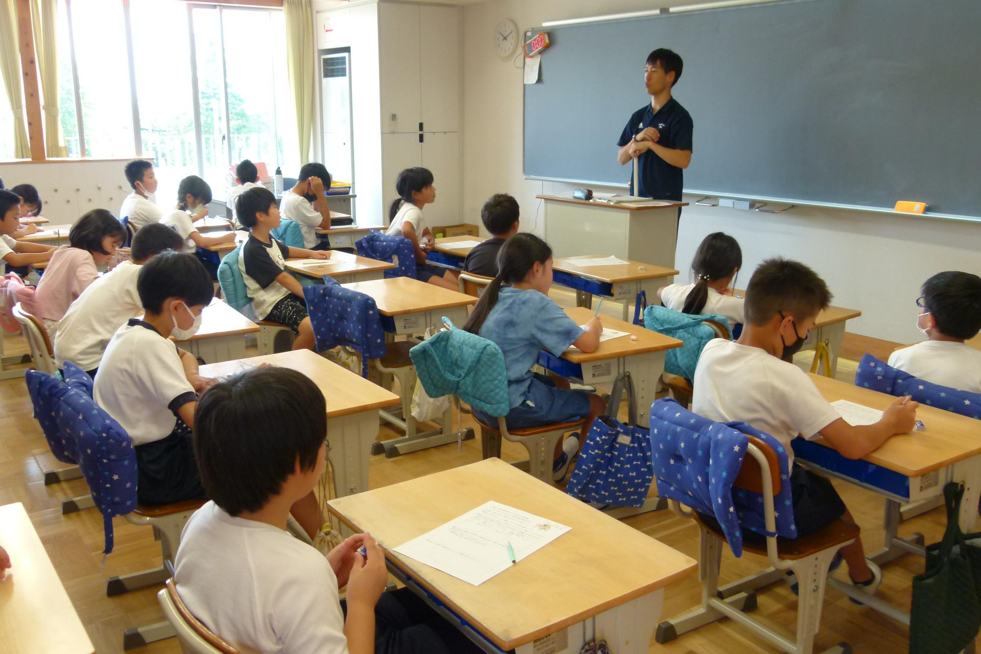 先生の話を聞く児童