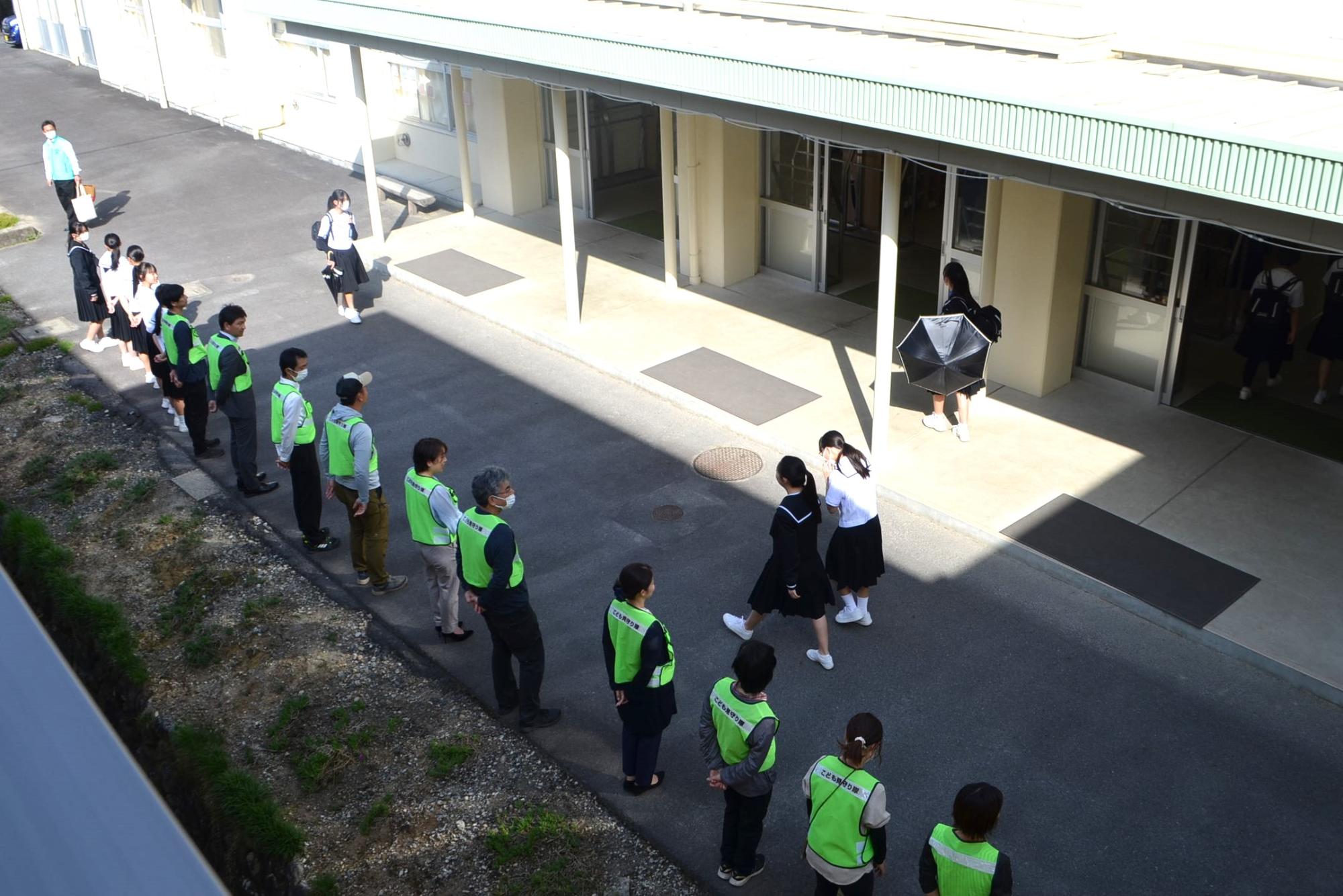 生徒玄関前であいさつ運動を行う様子