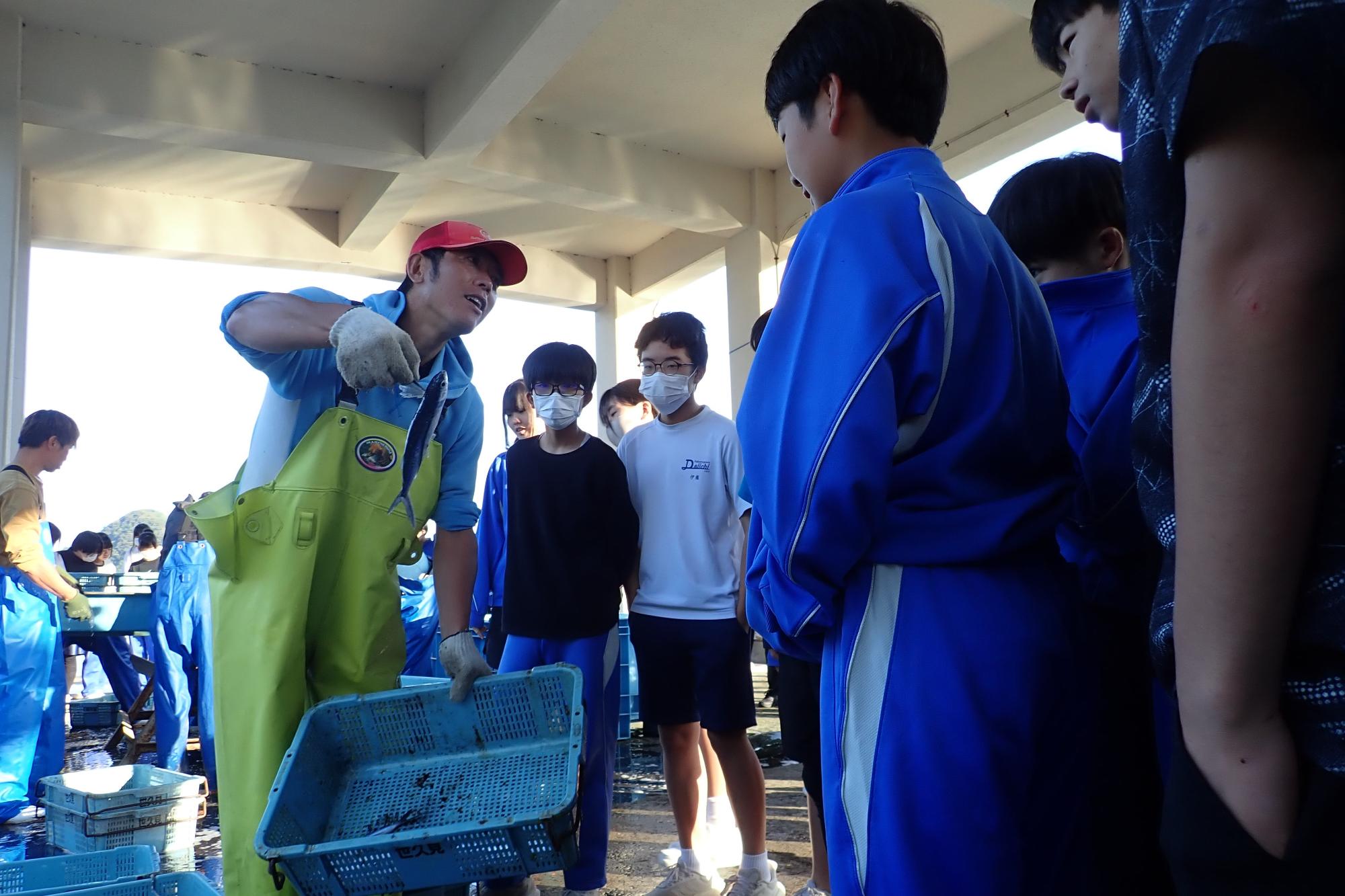 漁師の方から魚の話を聞いている様子