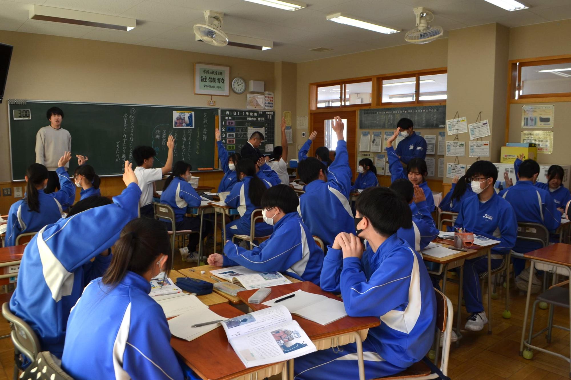 挙手して発言する生徒