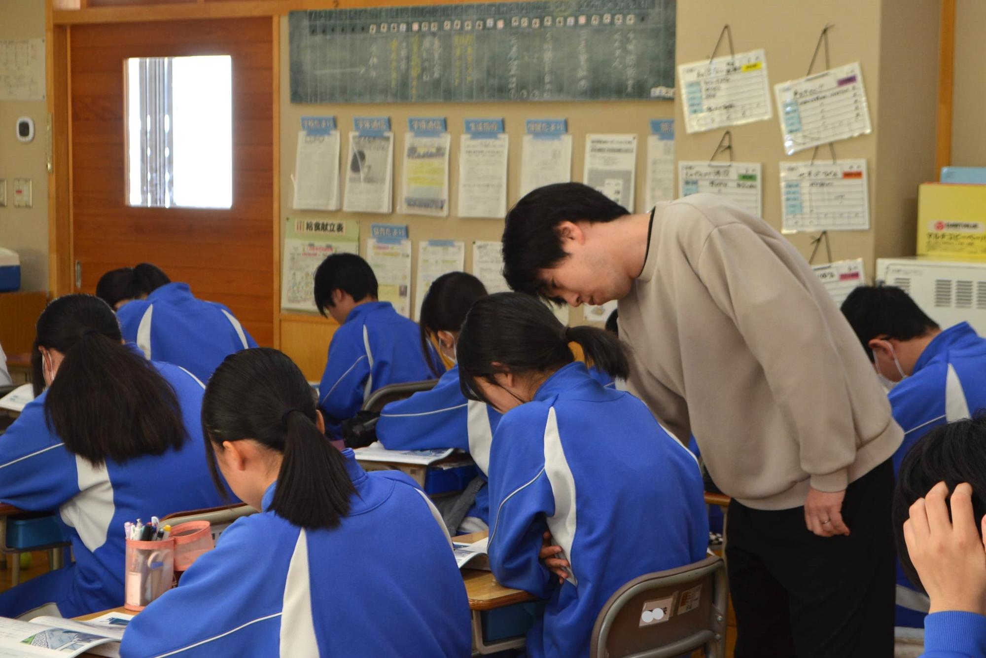 生徒の考えを見届ける教員