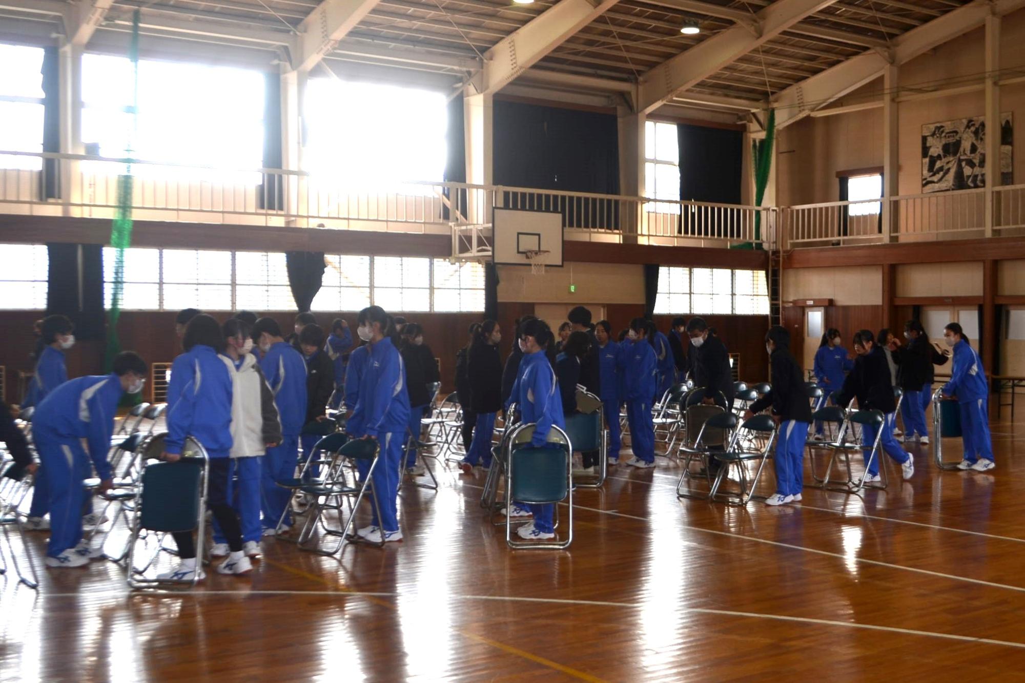 体育館に椅子を並べる生徒