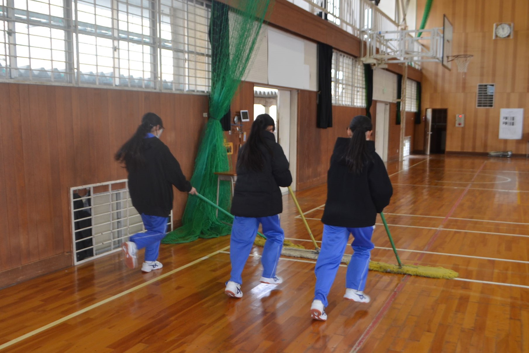 体育館にモップをかける生徒