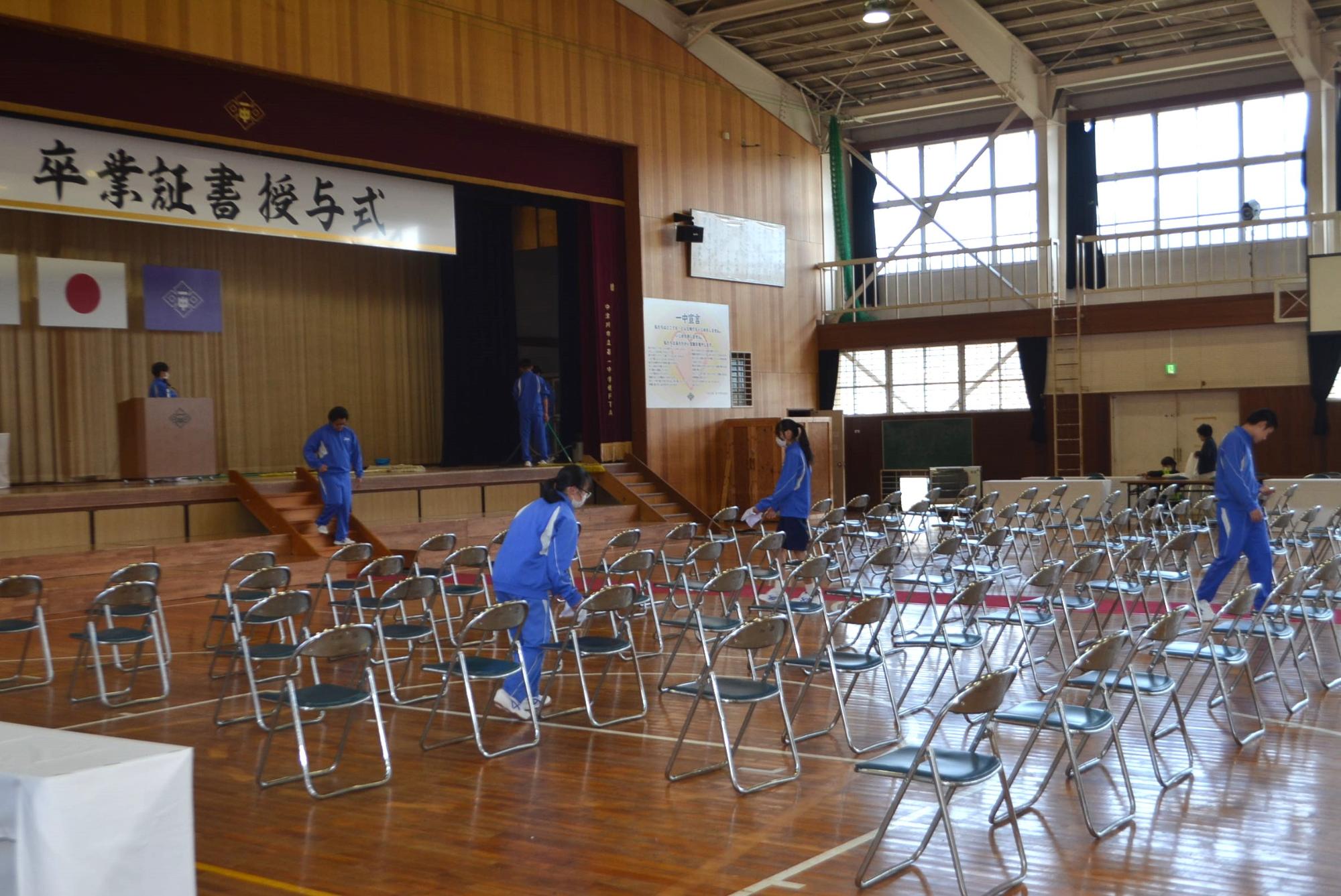 会場の椅子を整える生徒