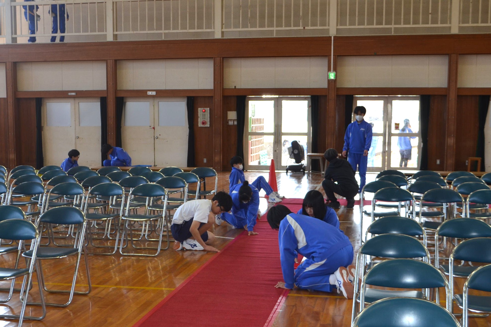 体育館のじゅうたんをきれいにする生徒