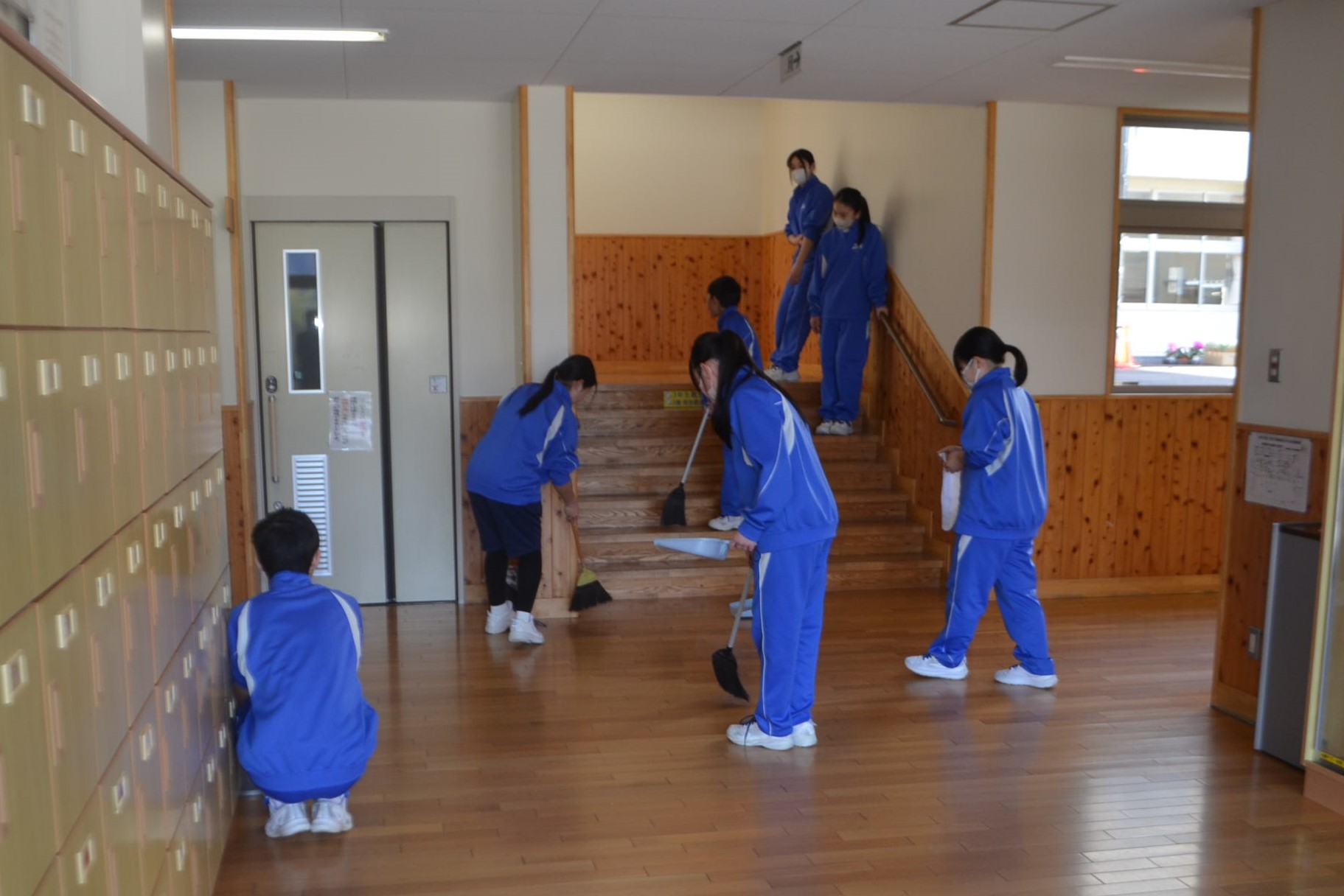 職員玄関前を掃除する生徒