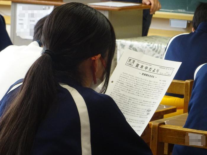 学校通信を読む女子生徒