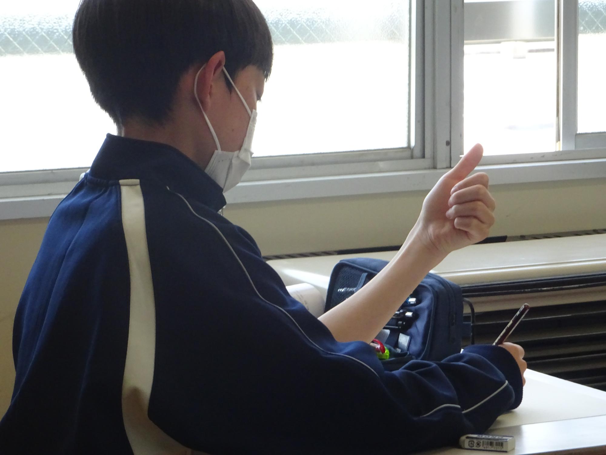 自分手を見つめデッサンする男子生徒