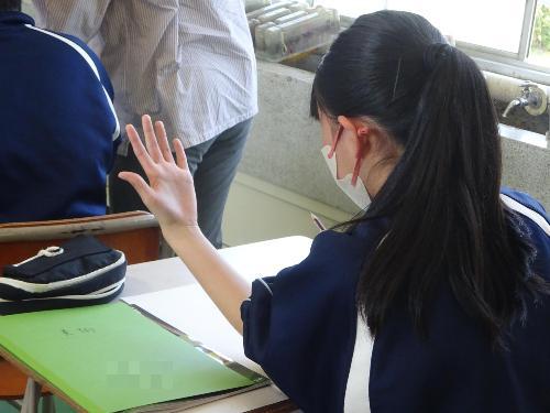 自分手を見つめデッサンする女子生徒